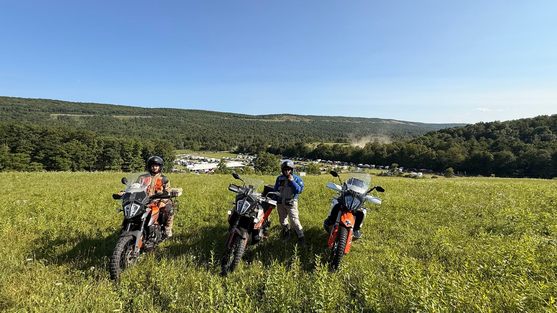Three bikes on the hill, with camp spread out below.