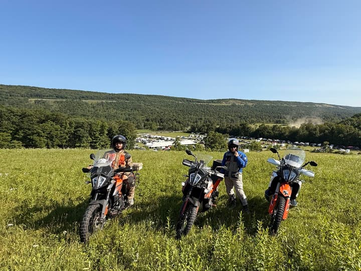 Three bikes on the hill, with camp spread out below.